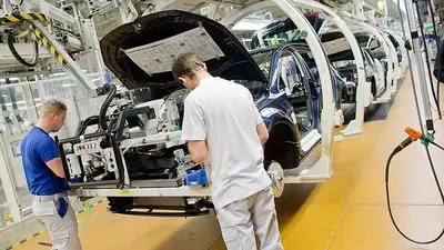 Employees work at  at the assembly  line for the Golf VII  at the  VW plant  in Wolfsburg, Germany Wednesday Oct. 21, 2015.  ( Julian Stratenschulte/Pool Photo via AP)