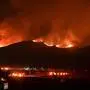 Fire trucks and public security vehicles are seen in the foreground as red glowing flames and smoke rise from the Hughes Fire in Castaic in northwest Los Angeles County, California, on January 22, 2025. A new wildfire erupted north of Los Angeles on January 22, exploding in size and sparking thousands of evacuation orders in a region already staggering from the effects of huge blazes. Ferocious flames were devouring hillsides near Castaic Lake, spreading rapidly to cover 5,000 acres (2,000 hectares) in just over two hours. (Photo by Robyn Beck / AFP)