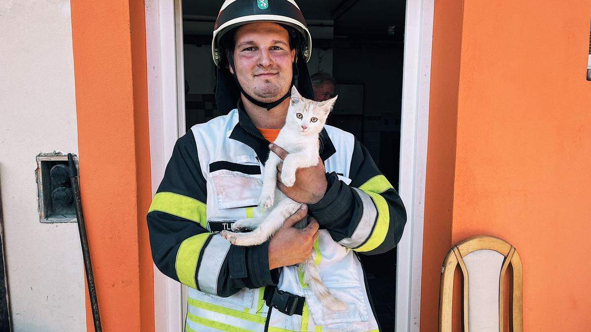 Ein Feuerwehrmann mit der geretteten Samtpfote