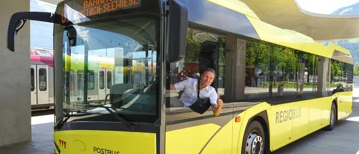 Ein gelber Bus aus dem ein Fahrer rauslacht