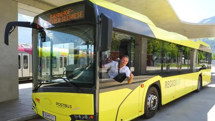 Ein gelber Bus aus dem ein Fahrer rauslacht