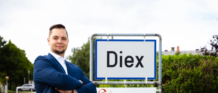 Der Kandidat vor einer Ortstafel der Gemeinde