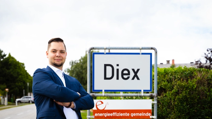 Der Kandidat vor einer Ortstafel der Gemeinde
