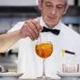 A bartender prepares a Spritz cocktail in a cafe in central Rome, on July 17, 2018.
Aperol is a historical brand which has existed since 1919 and had a strong growth but only in some regions in Italy. The Spritz tradition comes from the occupation of Italy by Austrian soldiers, who when a wine was not very good or hot added sparkling mineral to it. / AFP PHOTO / Andreas SOLARO
