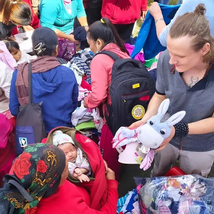 Köck beim Verteilen von gesammelter Kleidung und Stofftieren in Nepal