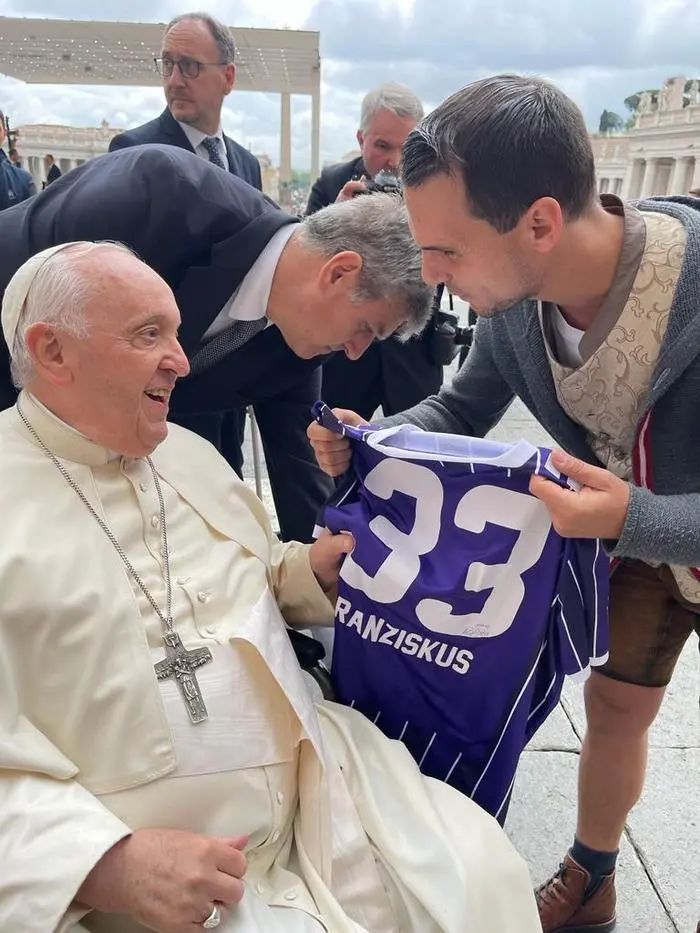 Entertainer Daniel Düsenflitz aus Ligist umrahmte mit einer Gruppe Blechbläser die Papst-Audienz am 17. Mai 2023 vor dem Petersdom im Vatikan

Daniel Düsenflitz übergab Papst Franziskus ein Fußballtrikot von Austria Salzburg mit der Aufschrift 