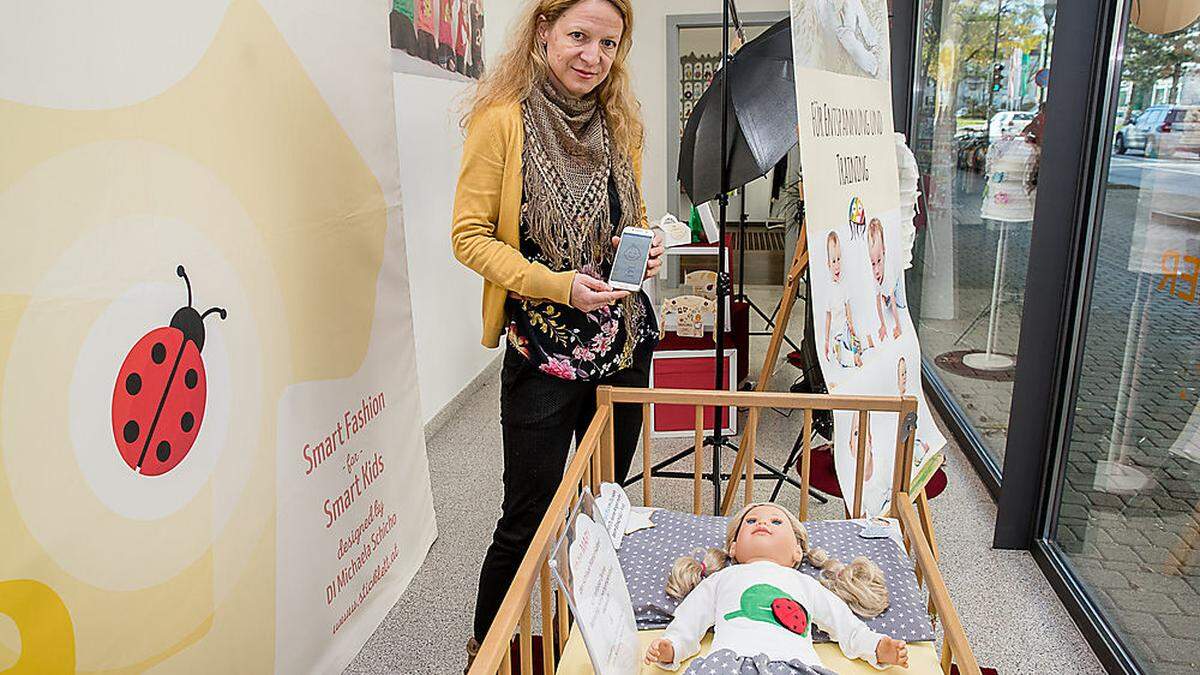 Michaela Schicho von Sticklett mit dem Käfer auf dem Baby-Oberteil, der bei Bedarf am Handy Alarm schlägt