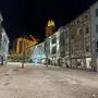 Ein großer menschenleerer Platz bei Nacht, die Fassaden und die große Kirche im Hintergrund sind beleuchtet