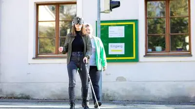 Kleine Zeitung-Redakteurin Verena Gangl versucht, sich mit dem weißen Langstock im Straßenverkehr zurechtzufinden – Linda Kanzler leitet sie an 