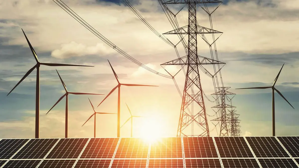 electricity power in nature. clean energy concept. solar panel with turbine and tower hight voltage sunset background