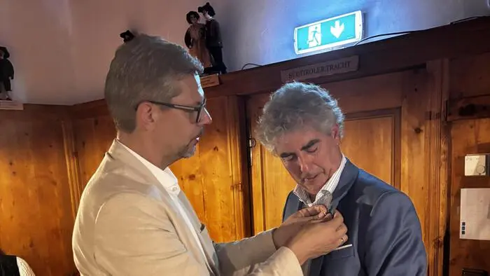 Bertram Steiner steckt Michael Takacs die Präsidentennadel an