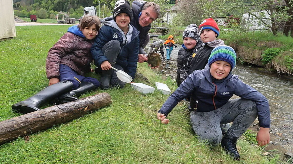 Biologe Otmar Winder klärt die eifrigen Volksschüler über die Tiere im Wasser auf