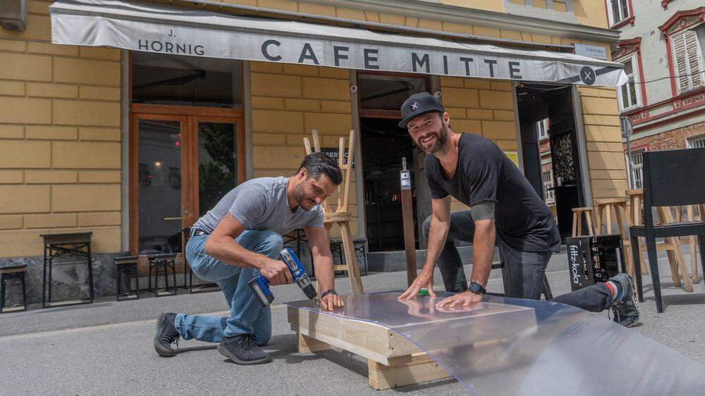 Café Mitte in Graz: René Koch bastelt mit einem Kollegen an den neuen Plexiglaswänden