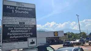 Man sieht einen Parkplatz und ein Schild mit dem Hinweis, dass maximal 1 Stunde geparkt werden darf