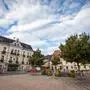 Zu sehen ist ein Hauptplatz, dahinter befindet sich ein Rathaus.