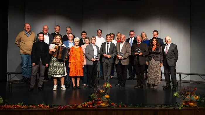 Viele Menschen stehen in Reih und Glied auf einer Bühne