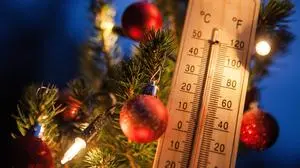 ABD0007_20151224 - ILLUSTRATION - Ein Holz-Thermometer mit der Temperaturanzeige von knapp 14 Grad Celsius (l) hängt am 23.12.2015 in Fellbach (Baden-Württemberg) zur blauen Stunde an einem Weihnachtsbaum neben Christbaumkugeln. Deutschlandweit wird es an Weihnachten deutlich zu warm für diese Jahreszeit sein. Foto: Christoph Schmidt/dpa +++(c) dpa - Bildfunk+++, sujet wetter, winter, klima, klimawandel, hohe temperaturen