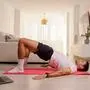 Sporty man doing bodyweight glute floor bridge pose at home