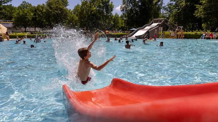 Das Bild zeigt ein Kind auf einer Wasserrutsche