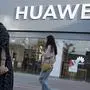 In this May 20, 2019, photo, a woman adjusts the glasses of a man outside a Huawei store in Beijing. The world's largest association of technology professionals has reversed a decision that would have excluded employees of Chinese tech giant Huawei and its affiliates from some editorial and peer review activities.(AP Photo/Ng Han Guan)