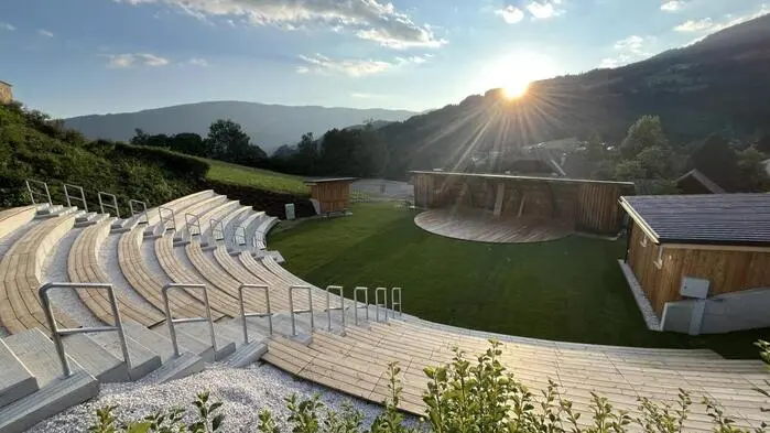 Eine Arena aus Holz eingebettet in eine grüne Landschaft