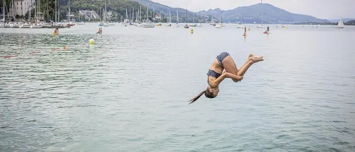 Ein Kind, das in den Wörthersee springt | 563.000 Personen sprangen heuer in den drei Strandbädern der Stadtwerke in den Wörthersee