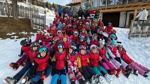 Die Kinder aus den Skiferienkursen sitzen im Schnee