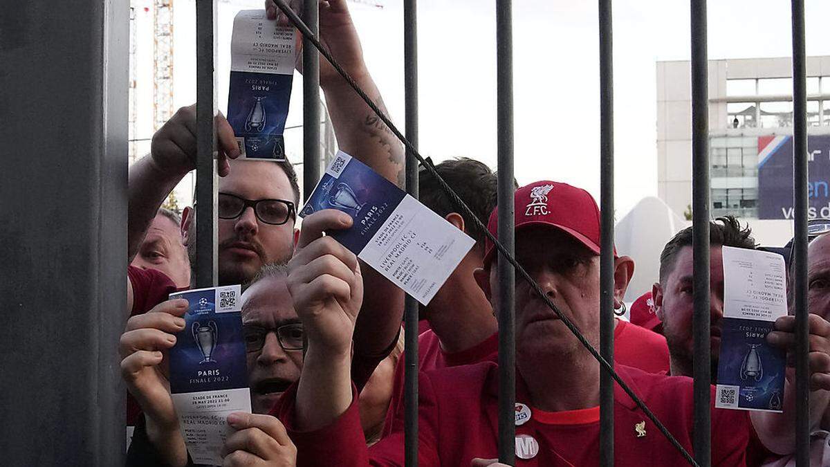 Fans, die nicht ins Stadion kamen, zeigen ihre Tickets.