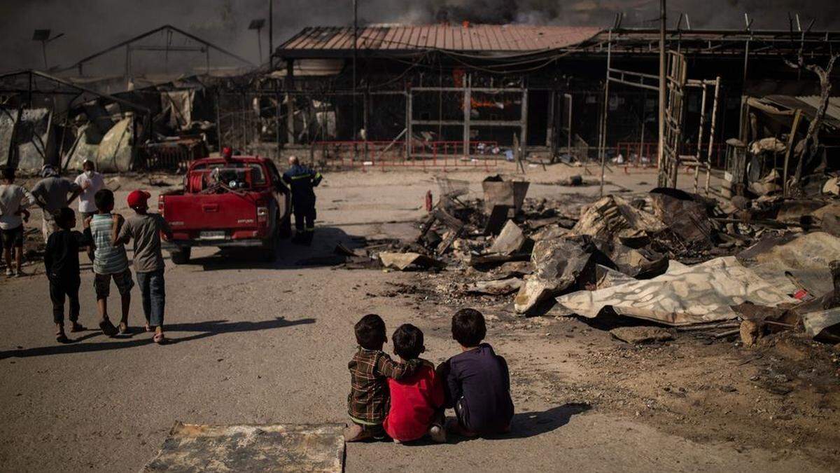 Kinder sitzen im abgebrannten Flüchtlingslager von Moria