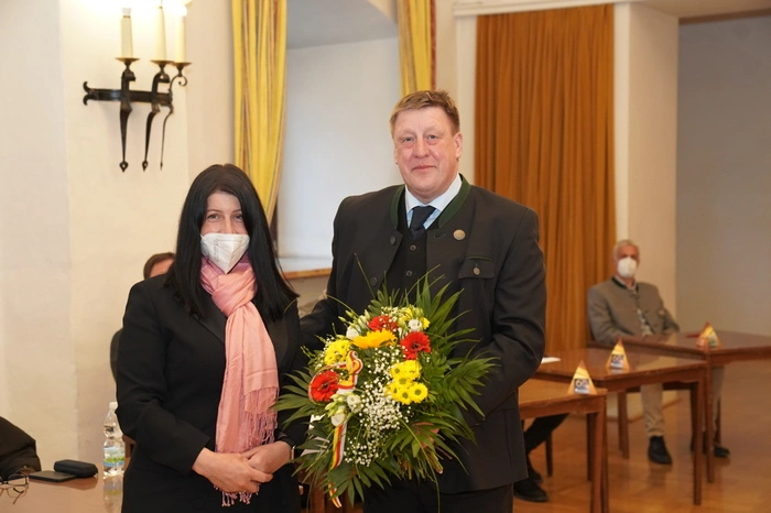 Die einzige Frau im Gemeinderat - Christine Ebner - erhält vom Bürgermeister einen Blumenstrauß 