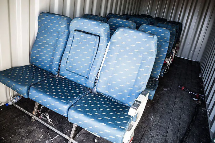 Um den Flugverkehr nicht zu stören, wurde ein Container auf einer Wiese außerhalb des Zaunes aufgestellt. Darin befanden sich die Flugzeugsitze.