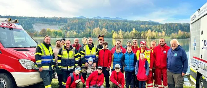 Ein Gruppenbild von Einsatzkräften vor einem See