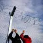 Two men stand next to a razor-topped fence close to the gate at the Greek-Macedonian border near the Greek village of Idomeni, on March 6, 2016, where thousands of people wait to cross the border into Macedonia.  Greece is likely to receive another 100,000 migrants by the end of the month, Europe's migration commissioner warned on March 6, 2016, two days ahead of an EU-Turkey summit seen as the only viable solution to the crisis. / AFP / DIMITAR DILKOFF,eu, europa, flüchtlinge, asylwerber, asylpolitik, flüchtlingspolitik, asyl, flüchtlingskrise 
,sujet zaun, grenzzaun