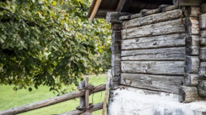 Altbauer Franz Rauter heizt den Ofen der Dörrhütte ein.