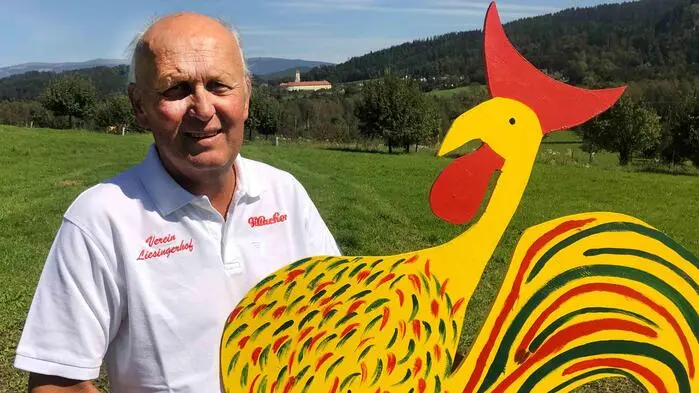 Ein Mann hält ein großes, gebasteltes Huhn in seinen Händen 