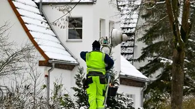 A maintenance worker service a gas powered street lamp in Slachtensee, southwest Berlin on January 5, 2026, after power cables in the area were seriously damaged causing a power outage which left tens of thousands of households in the German capital without electricity. The attack on the power grid in parts of Berlin was most likely carried out by left-wing extremists. A letter claiming responsibility from a left-wing extremist group calling itself 'Vulkangruppe' has been deemed "credible" based on the current state of the investigation, a police spokesperson said in Berlin on January 4. However, the investigation into the motive is still ongoing. Berlin's Senator for Economic Affairs had previously stated that the widespread power outage, which began early January 3 and affected tens of thousands of households, was deliberately caused by incendiary devices. A total of five high-voltage and ten medium-voltage cables were destroyed or damaged "by multiple incendiary devices." (Photo by RALF HIRSCHBERGER / AFP)
