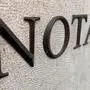 Eine helle Wand mit der Aufschrift „Notar“