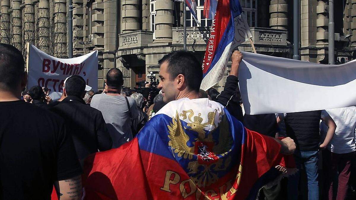 Mann mit russischer Flagge bei einem anti-NATO-Protest Belgrad.