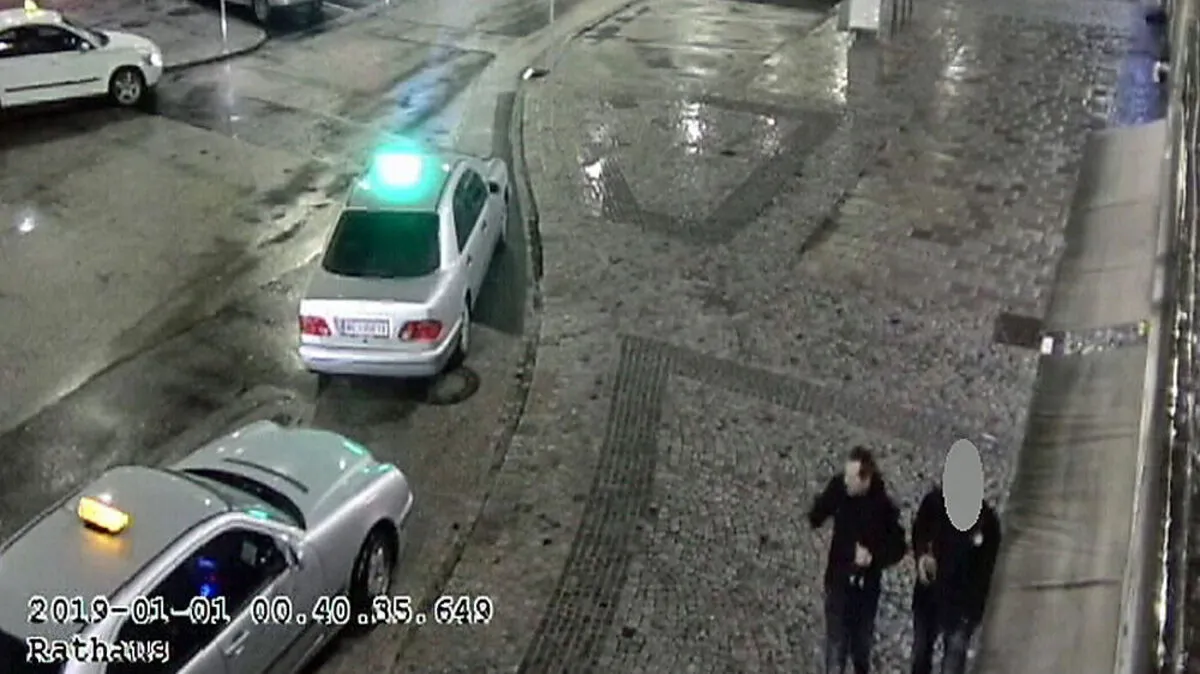 Foto, das die Polizei vom Verdächtigten veröffentlichte (linke Person in der rechten unteren Bildhälfte)
