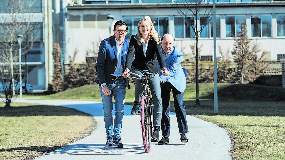 Verena ­Robinson, ihr Vater Heinz ­Robinson (rechts) und der ­Geschäftsführer Paul Schweig­hofer (links) mit einem  Styria-Fahrrad von 1927 – wie  es ihr Urahn am ersten Standort auch verkauft hat
