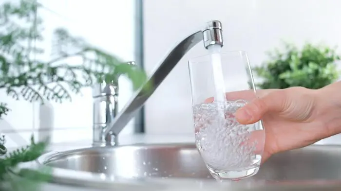 Ein Wasserhahn aus dem Wasser sprudelt 