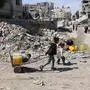 Palestinian children head to a water distribution point to fill their containers in Gaza City on May 4, 2025. The humanitarian crisis in the besieged Gaza Strip has worsened significantly since Israel blocked all aid from entering the territory on March 2, days before resuming its military campaign following the collapse of a ceasefire. (Photo by Omar AL-QATTAA / AFP)