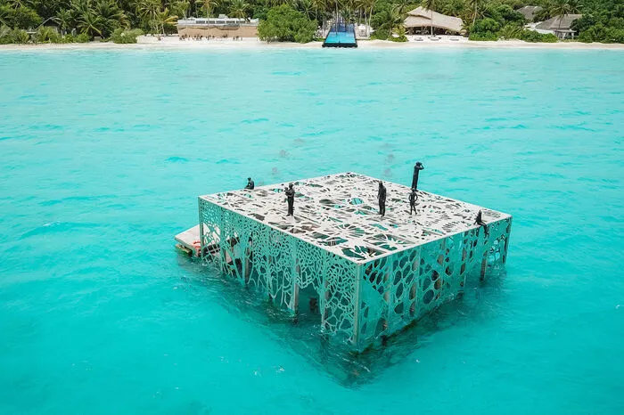 Herzstück der Installation ist ein riesiger, nach unten geöffneter, durchlässiger Edelstahl-Kunstwürfel, dessen Außenwände aus ausgestanzten Platten bestehen, deren Maserung der Gorgonian Fächerkoralle nachempfunden ist.
