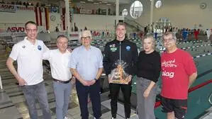 Sechs Personen stehen am Rand eines großen Schwimmbeckens