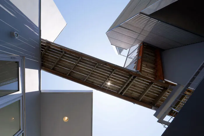 Das mit Stahl verkleidete Gebäude besteht aus zwei separaten Türmen, die durch eine Brücke im Obergeschoss miteinander verbunden sind. Die Verwendung von Beton in Kombination mit Holz und Metall findet sich im ganzen Haus wieder. 