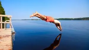 Young man jumping into water, summer time