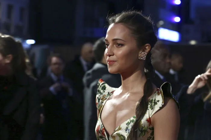 ... die Fotografen fokussierten sich jedoch auf die schwedische Oscarpreisträgerin ("The Danish Girl"), die sich trotz taffer Rolle auf dem roten Teppich sanft in einer floralen Robe zeigte ...