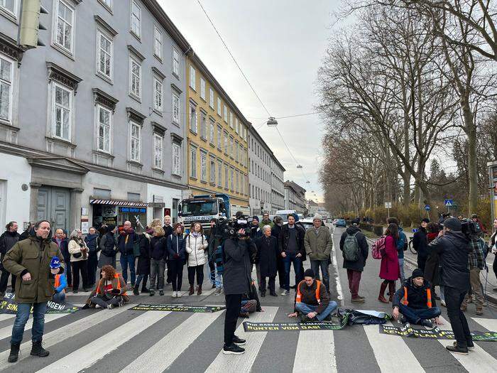 Begleitet wurden die Aktivistinnen und Aktivisten von rund 30 Personen, die bei der Blockade hinter ihnen stehen: Wissenschaftlerinnen und Wissenschaftler aus Graz unterstützen die Aktion