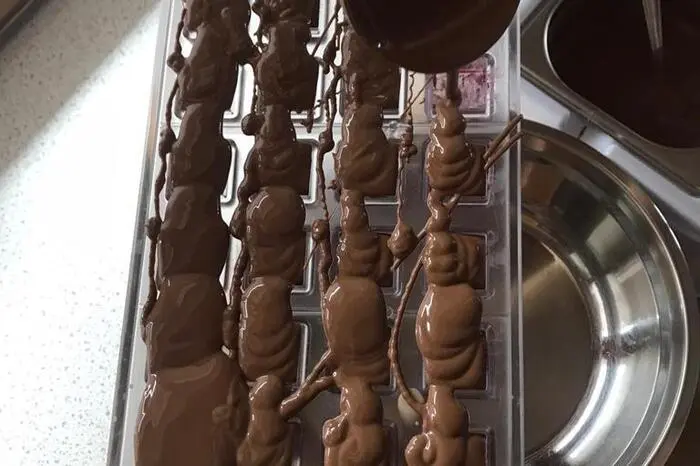 Die wiederum ausgekühlten Pralinen werden dann mit Kuvertüre bedeckt ...