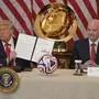 FILE - President Donald Trump holds the sign charter for the 2026 FIFA World Cup soccer tournament task force in the East Room of the White House, Tuesday, May 6, 2025, in Washington, as FIFA President Gianni Infantino watches. (AP Photo/Mark Schiefelbein, File)